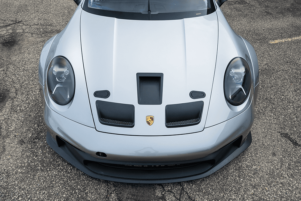 Front view of a white 2021 Porsche 911 GT3 Cup 992 race car with aerodynamic features.