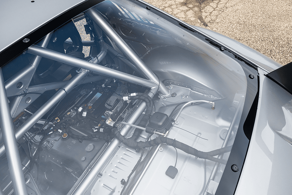 Close-up of the interior of a 2021 Porsche 911 GT3 Cup 992 race car showing roll cage and engine bay.