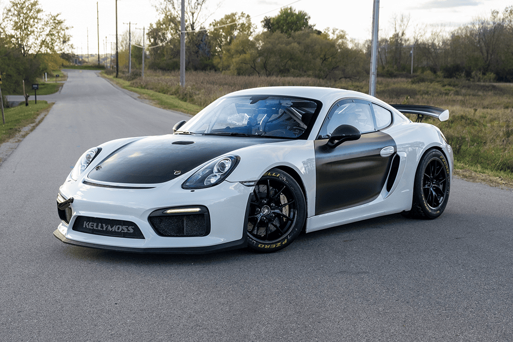 2016 Porsche 981 Clubsport MR with black and white exterior on a rural road.