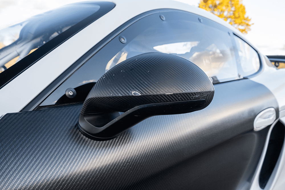 Close-up of a carbon fiber side mirror on a Porsche 981 Clubsport MR.