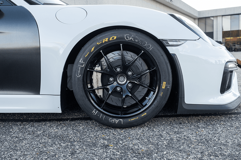 Close-up of a white Porsche 981 Clubsport MR wheel and tire.