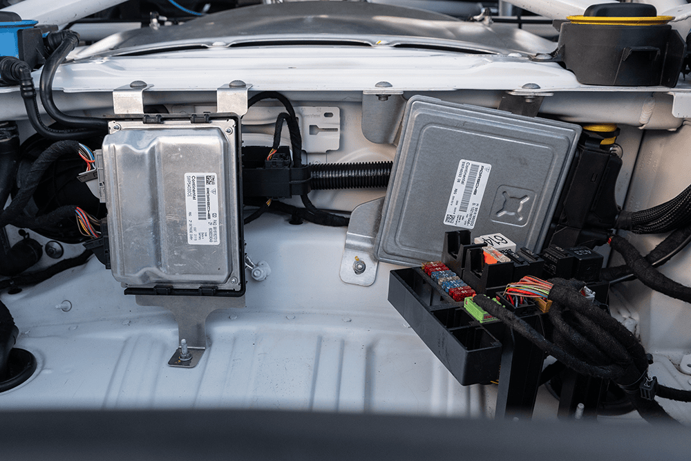 Close-up of Porsche 981 engine control units and wiring harness.