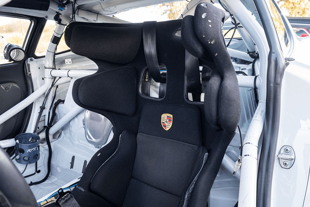 Racing seat inside a 2016 Porsche 981 Clubsport MR with safety harness.