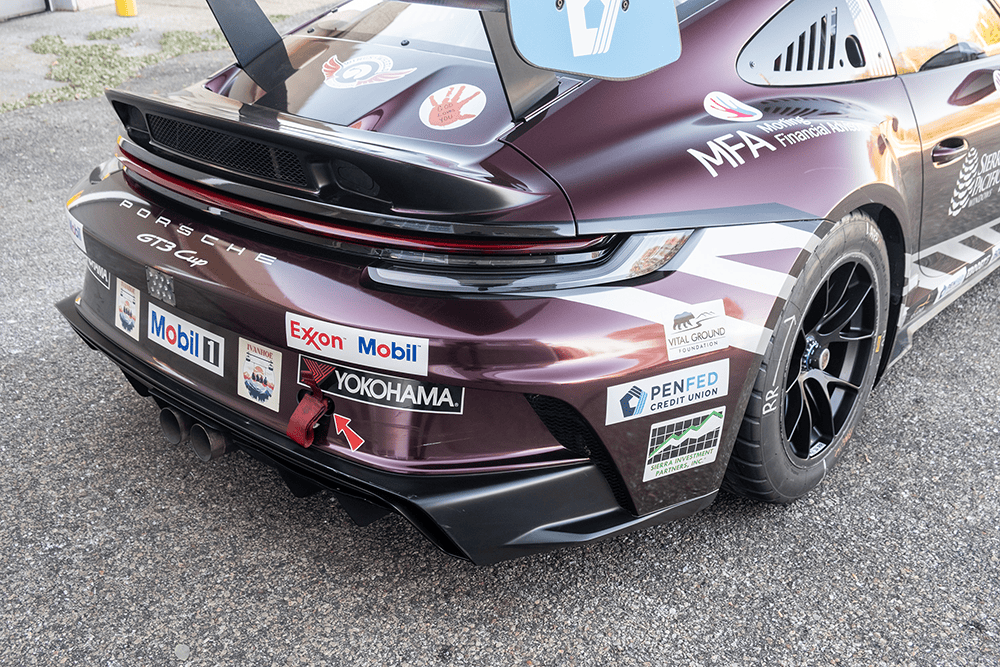 Close-up of a Porsche 911 GT3 Cup race car with sponsor decals and racing livery.