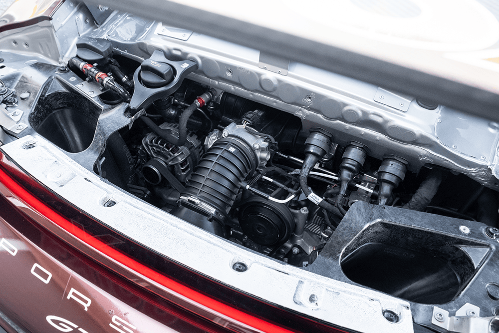Close-up of the Porsche 911 GT3 Cup 992 engine showing mechanical components.