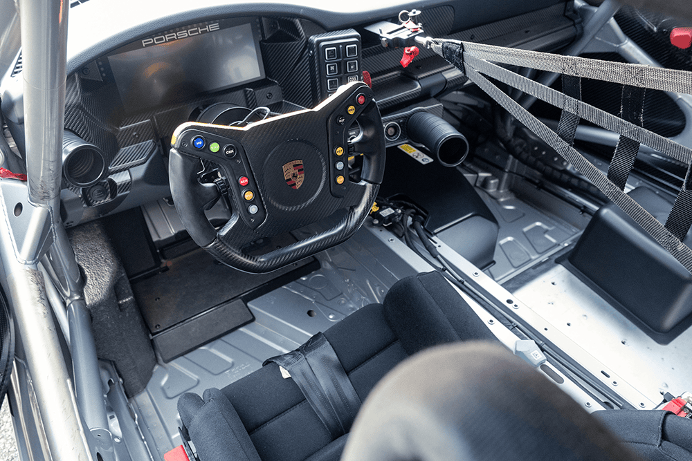 Close-up of Porsche 911 GT3 Cup 992 racing car interior dashboard and steering wheel.