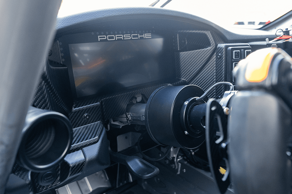 Close-up of the Porsche 911 GT3 Cup 992 dashboard and steering wheel.