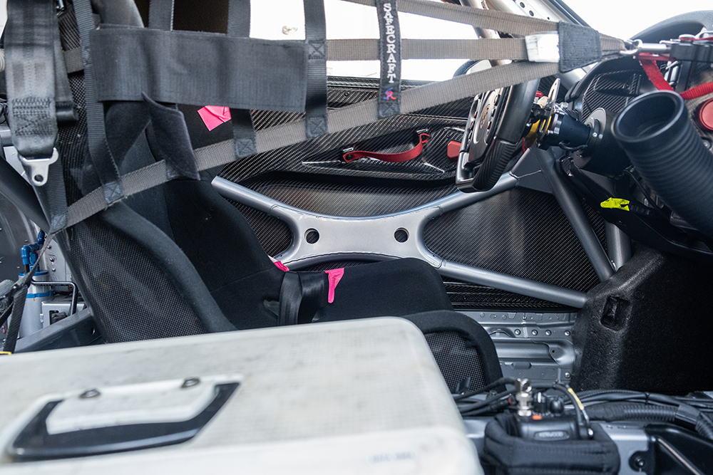 Racing car interior with racing seat and dashboard of Porsche 911 GT3 Cup 992.