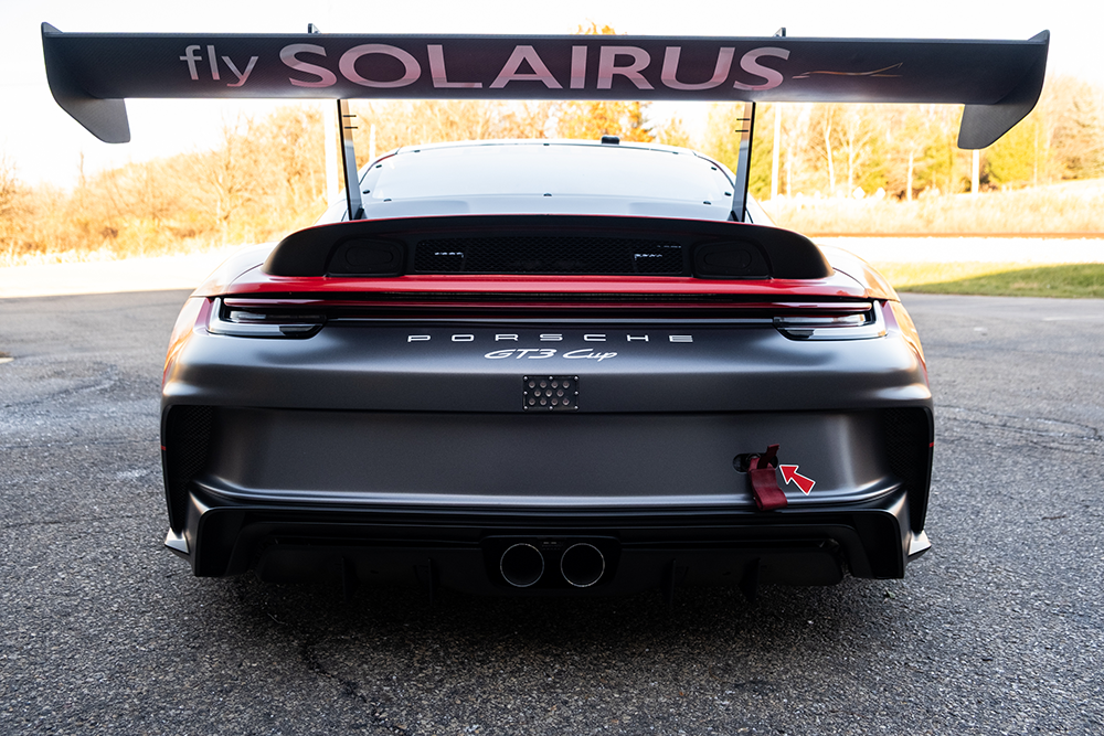 Rear view of a Porsche 911 GT3 Cup 992 with racing wing and branding.