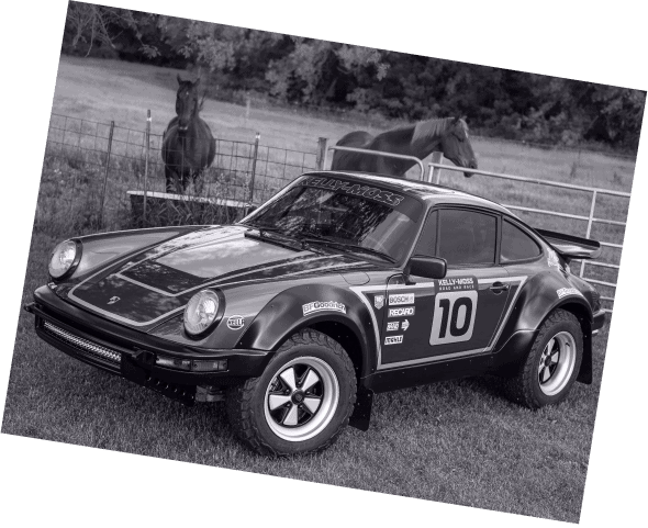 Classic Porsche race car with racing number 10 in a grassy field.