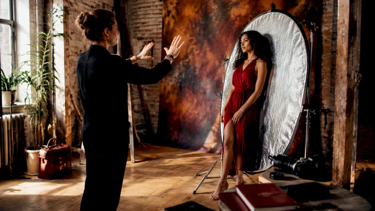 Photographer directing model posing in studio
