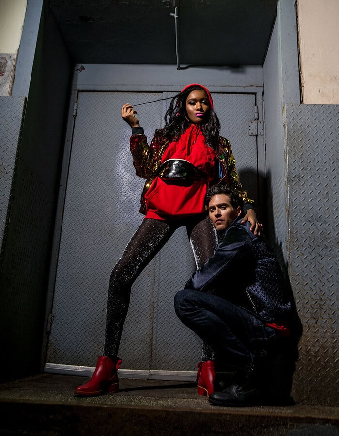 Fashion photo featuring a woman in red and black outfit with a man in urban setting.