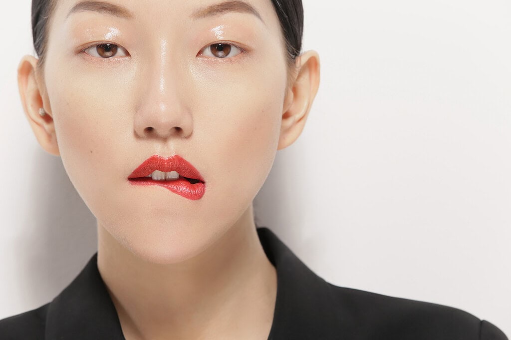 Close-up portrait of a woman with bold red lipstick and minimal makeup. photographer NYC