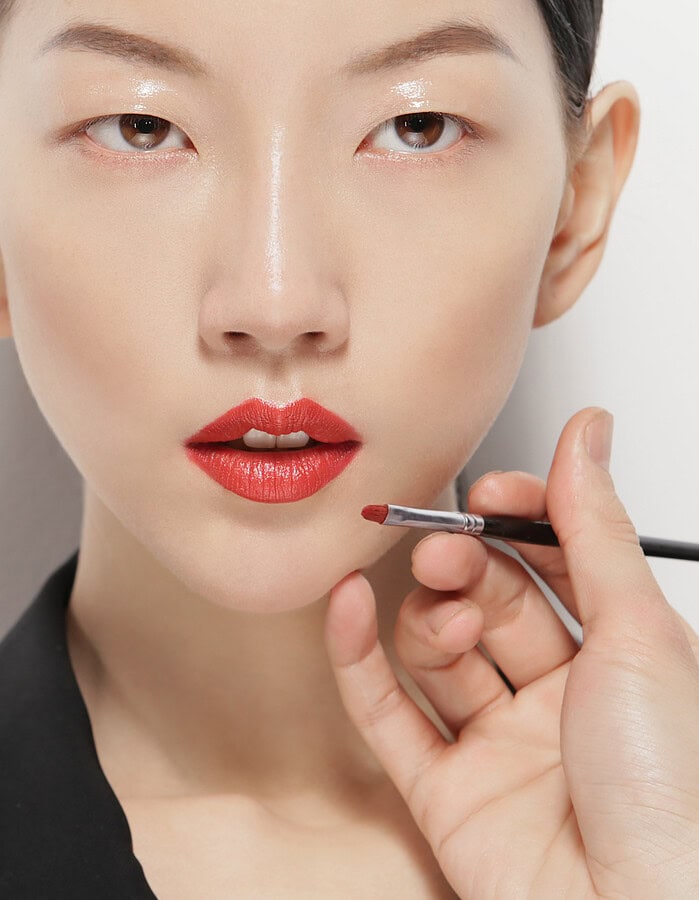 Close-up of a woman getting her makeup done with a brush. photographer NYC