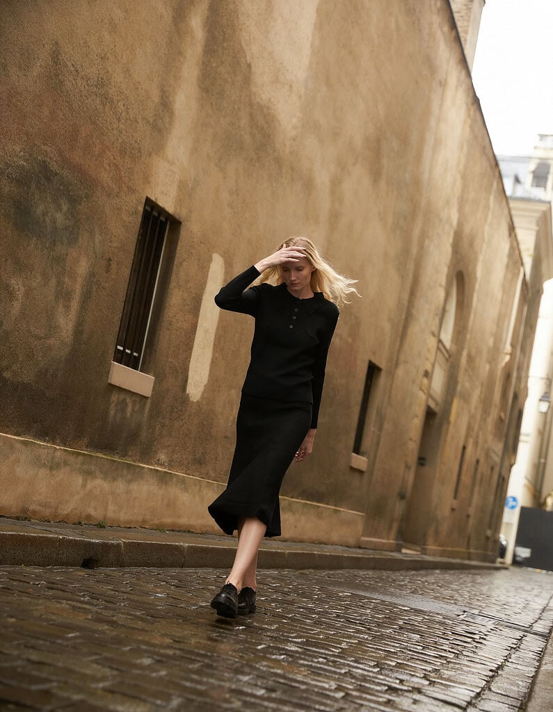 Fashionable woman walking on cobblestone street in urban setting. photographer NYC