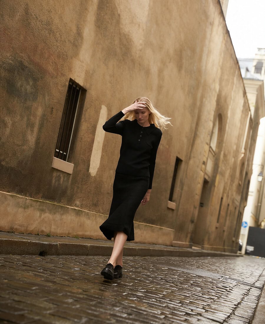 Fashionable woman walking on cobblestone street in urban setting. photographer NYC