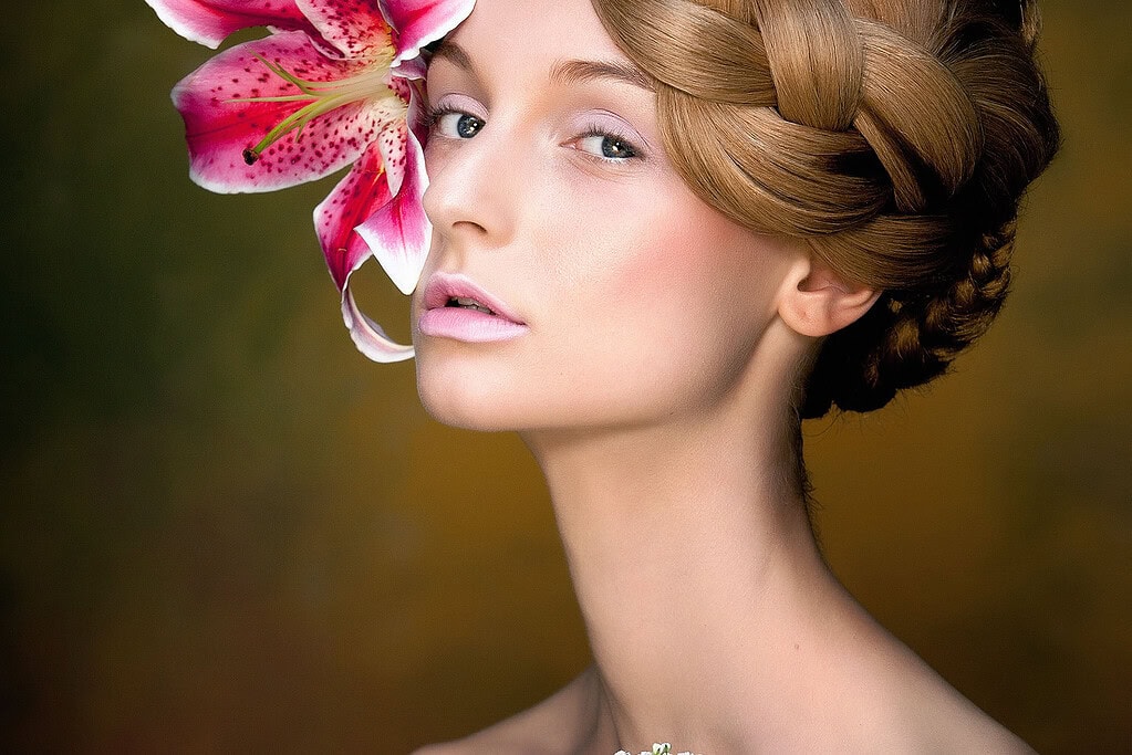 Beauty image of a European woman with an orchid in her hair