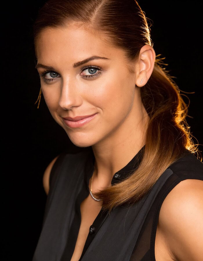 Alex Morgan photographed on a New York City street with softly blurred buildings behind her.