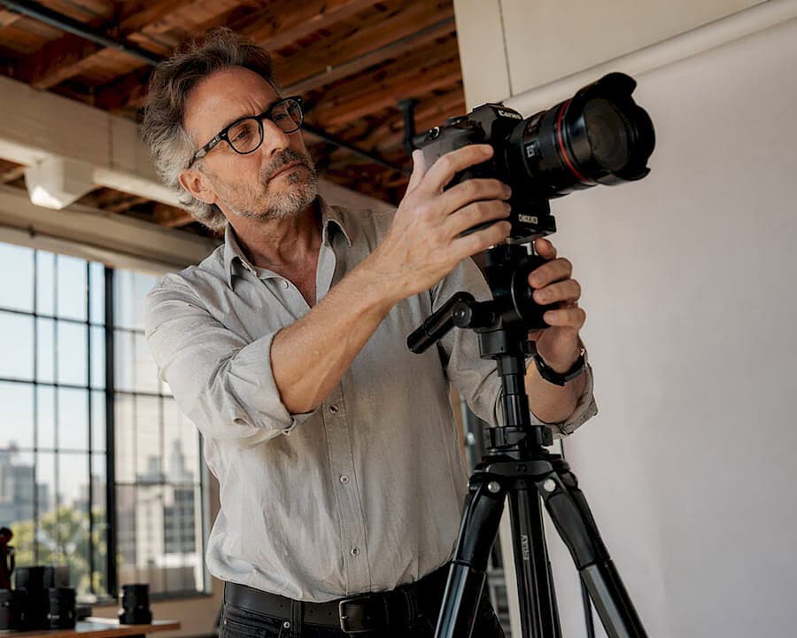 Photographer adjusting camera in NYC studio