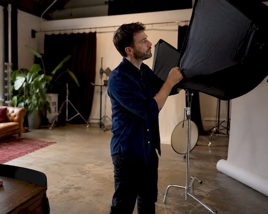 Photographer adjusting studio overhead lighting