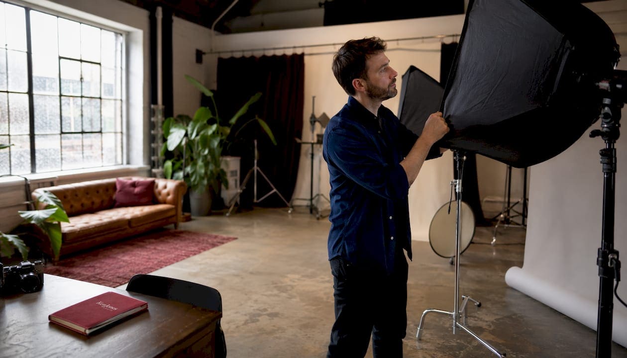 Photographer adjusting studio overhead lighting