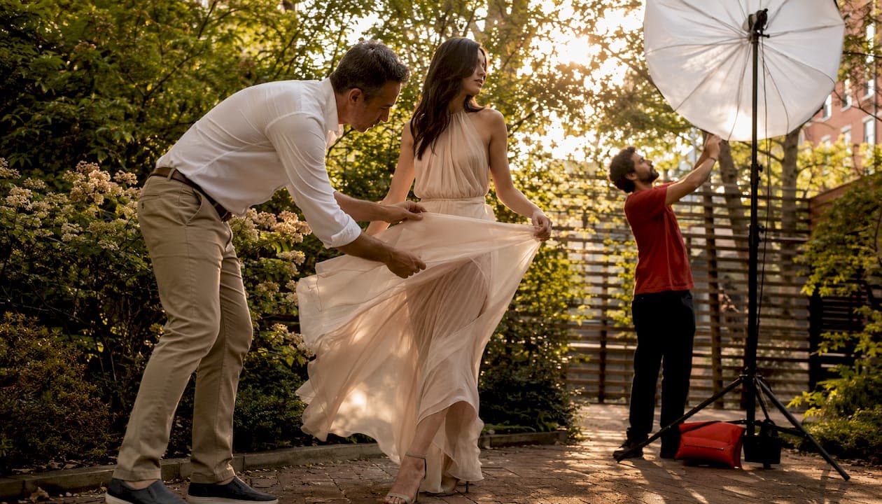 Photographer adjusting fabric for movement shot in loft studio