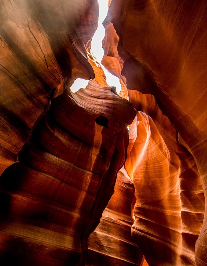 Vertical view of warm sandstone walls and reflected light inside Antelope Canyon.