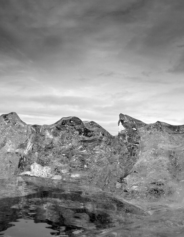 Black and white view of a jagged ice ridge against cloudy sky in Iceland.