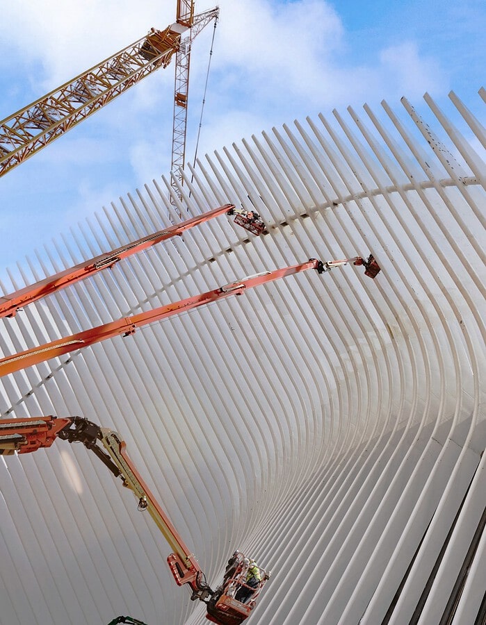 Construction lifts working on the white exterior ribs of the World Trade Center Oculus in Lower Manhattan.