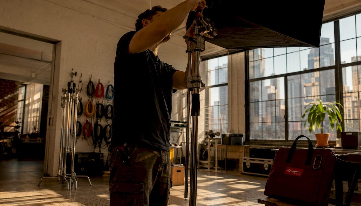 Lighting technician adjusting modular lighting grip in studio