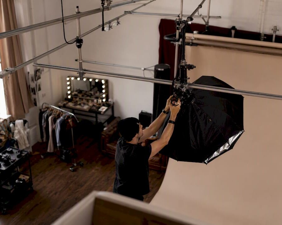 Production team adjusting lights in NYC photo studio