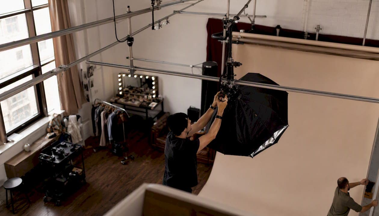 Production team adjusting lights in NYC photo studio