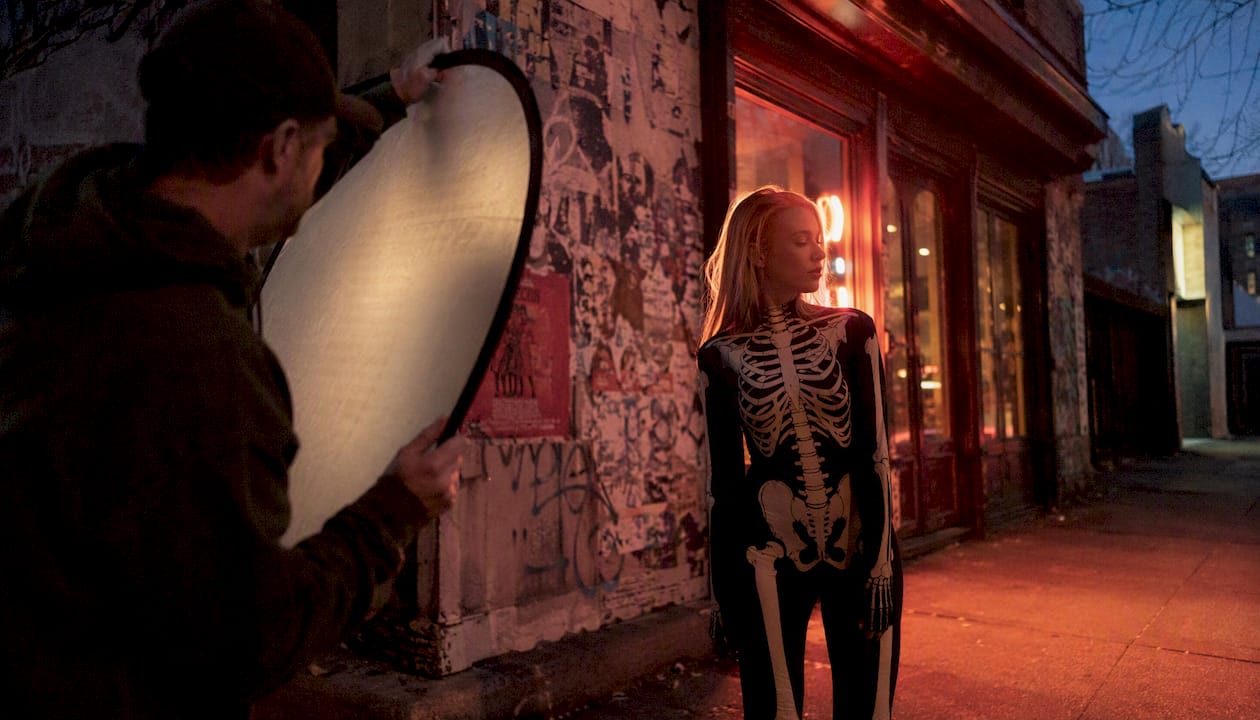 Model in skeleton suit on residential street at dusk