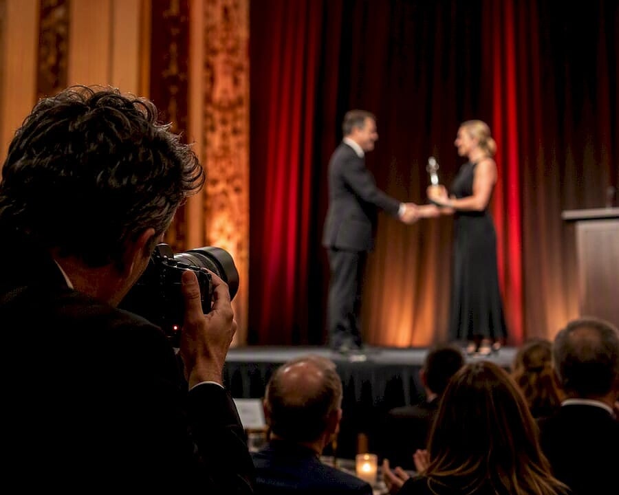 Photographer shooting award winner on stage