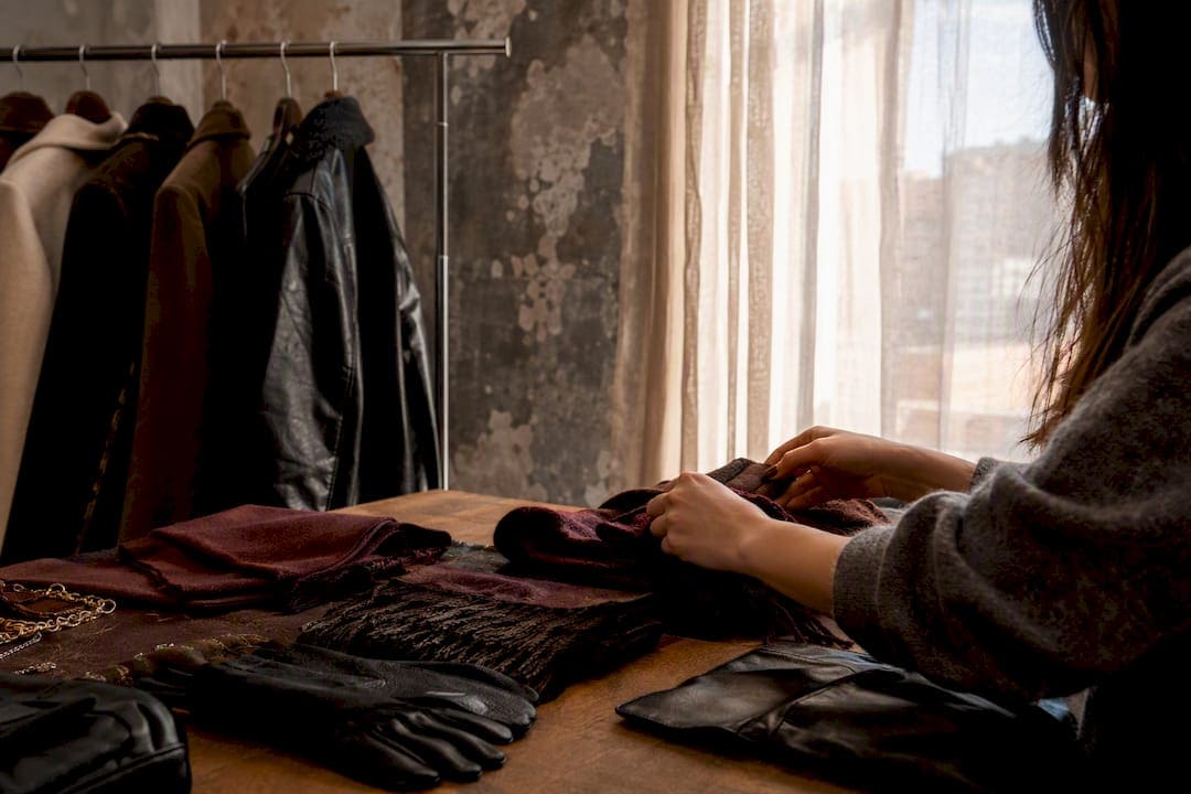 Hands arranging seasonal textured wardrobe in studio