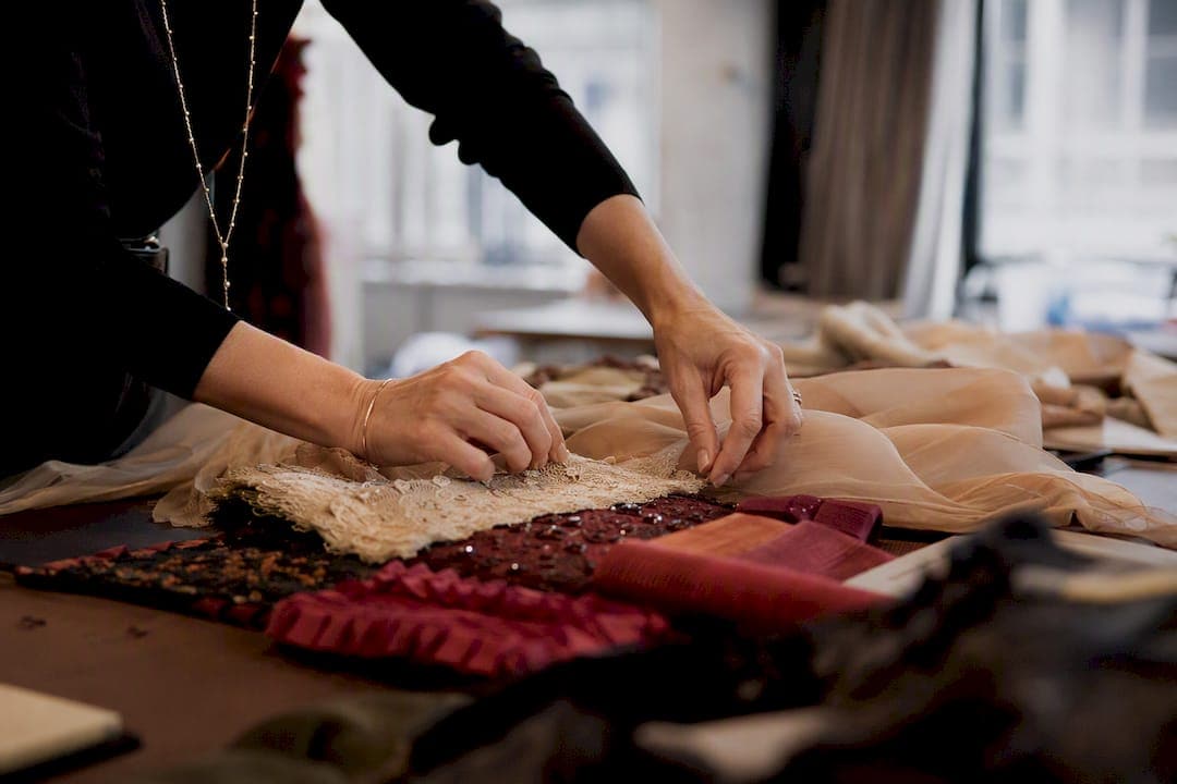 Hands styling fabric and accessories on set