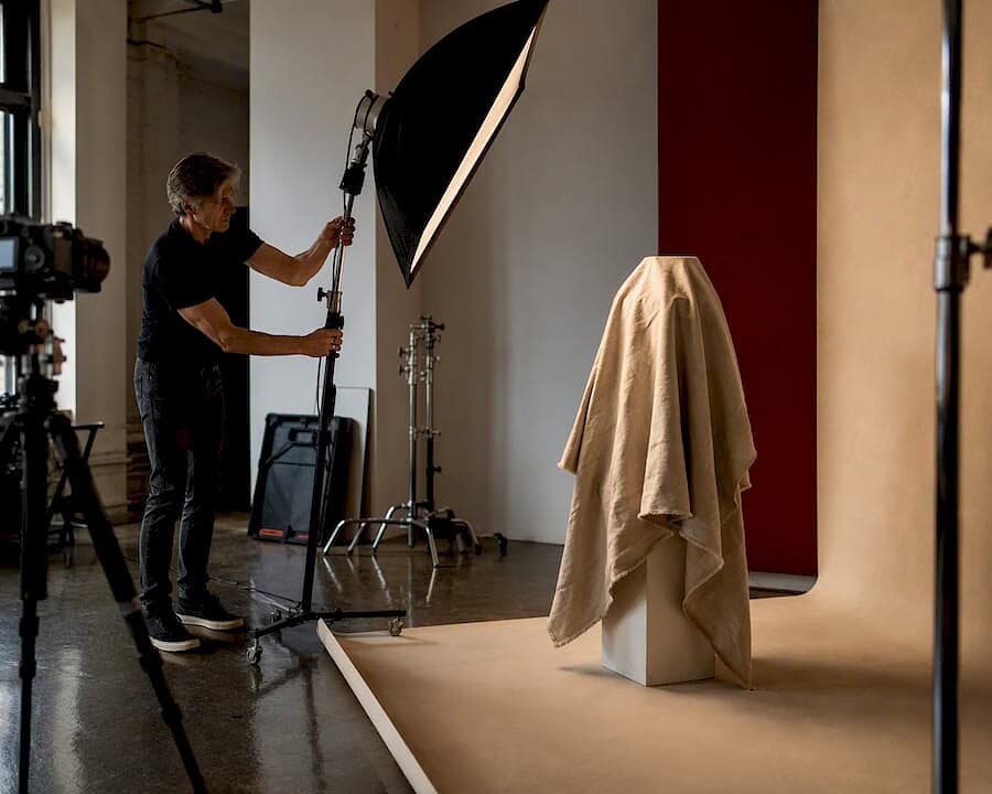 Photographer adjusting studio lighting for product shoot