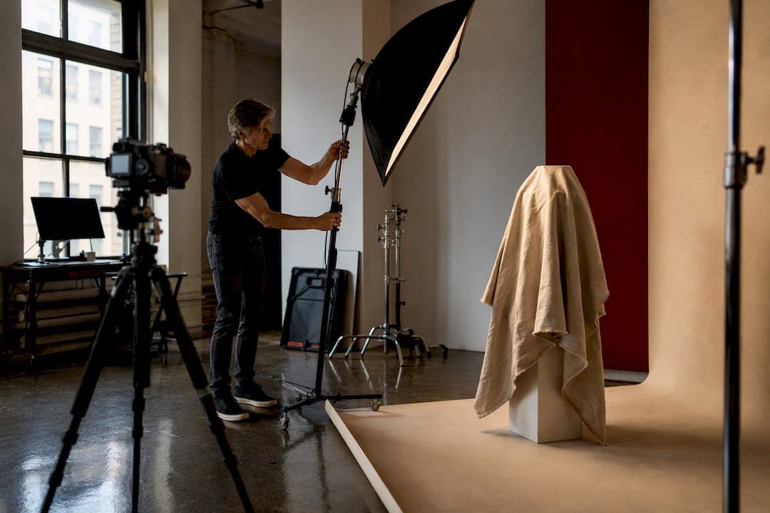 Photographer adjusting studio lighting for product shoot