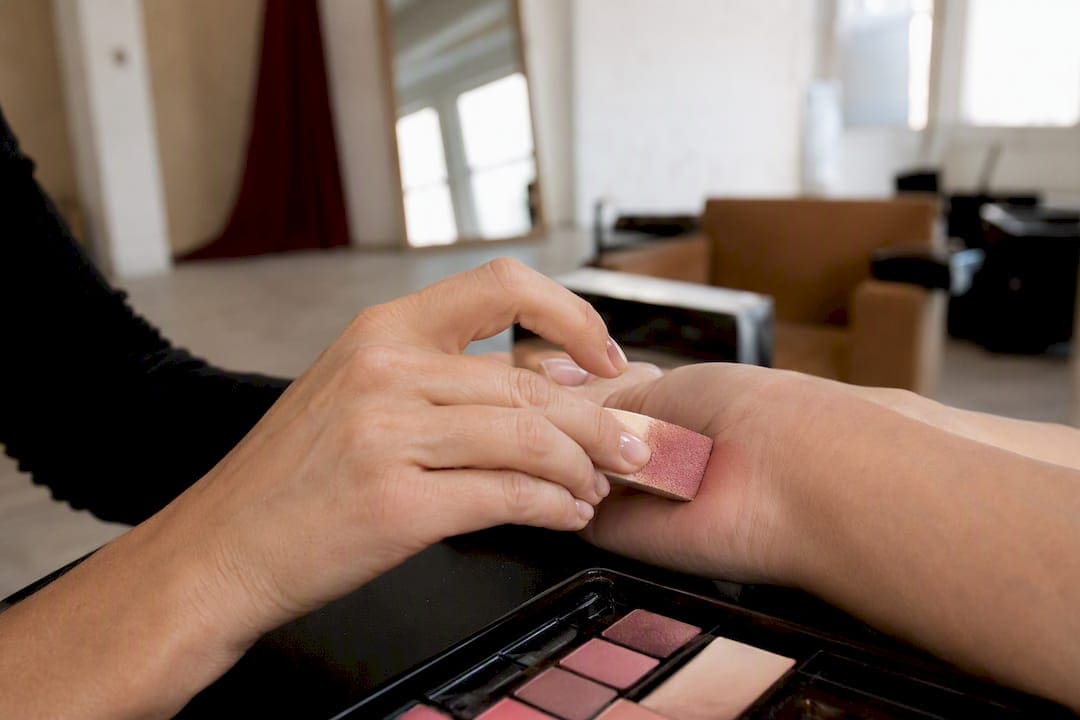 Hand applying layered cosmetics swatch