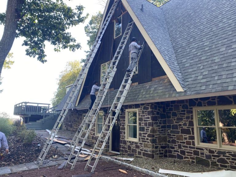 Installing new windows and siding on a house during renovation project.