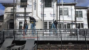 Skilled workers installing energy-efficient siding on a residential home.