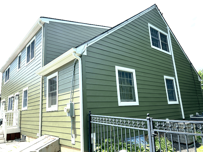 Green James Hardie Hardie Plank siding with white trim and windows in Yardey, PA.