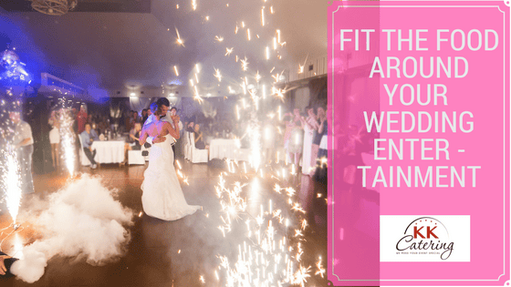 Groom and bride dancing at wedding reception with sparklers and entertainment in a decorated venue.