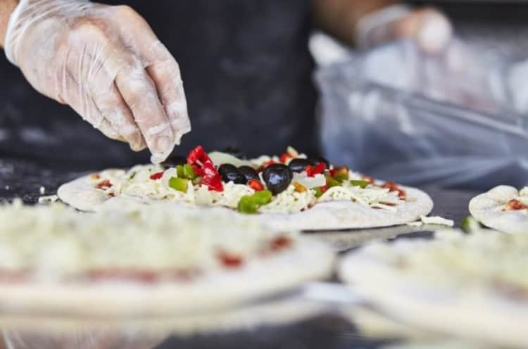 Freshly prepared pizza with fresh toppings at KK Catering, expert in catering services in the UK.