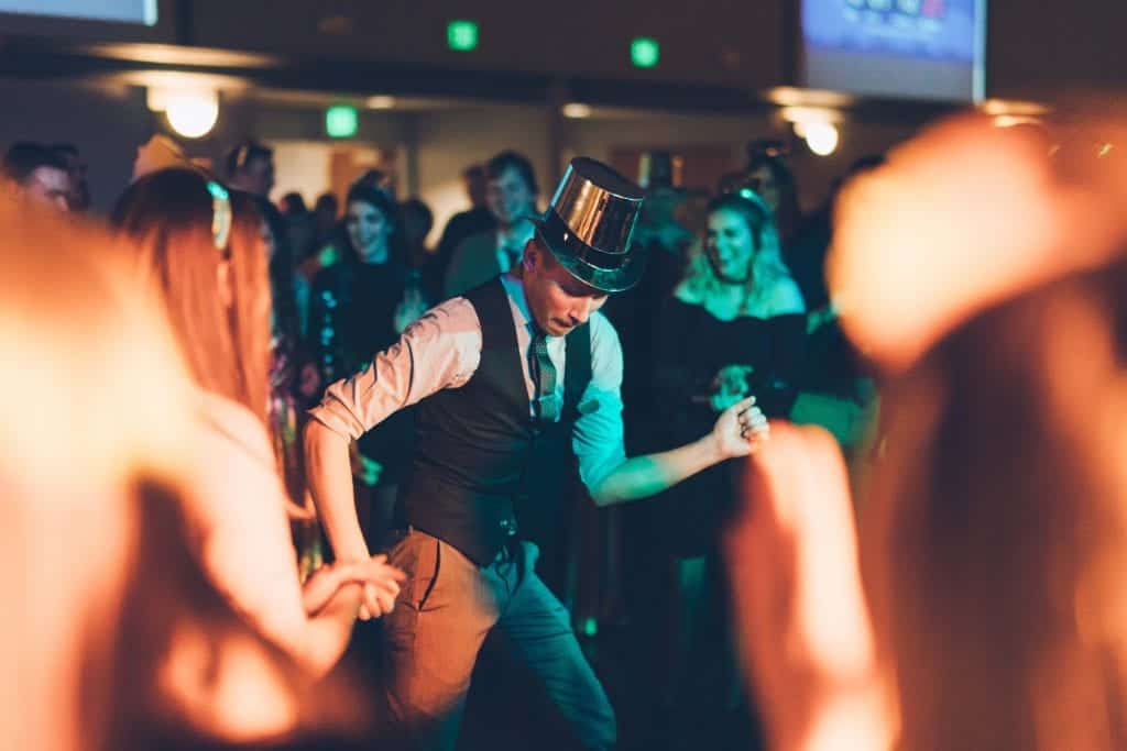 Party dancer wearing a top hat at a lively celebration event; fun, entertainment, and dance.