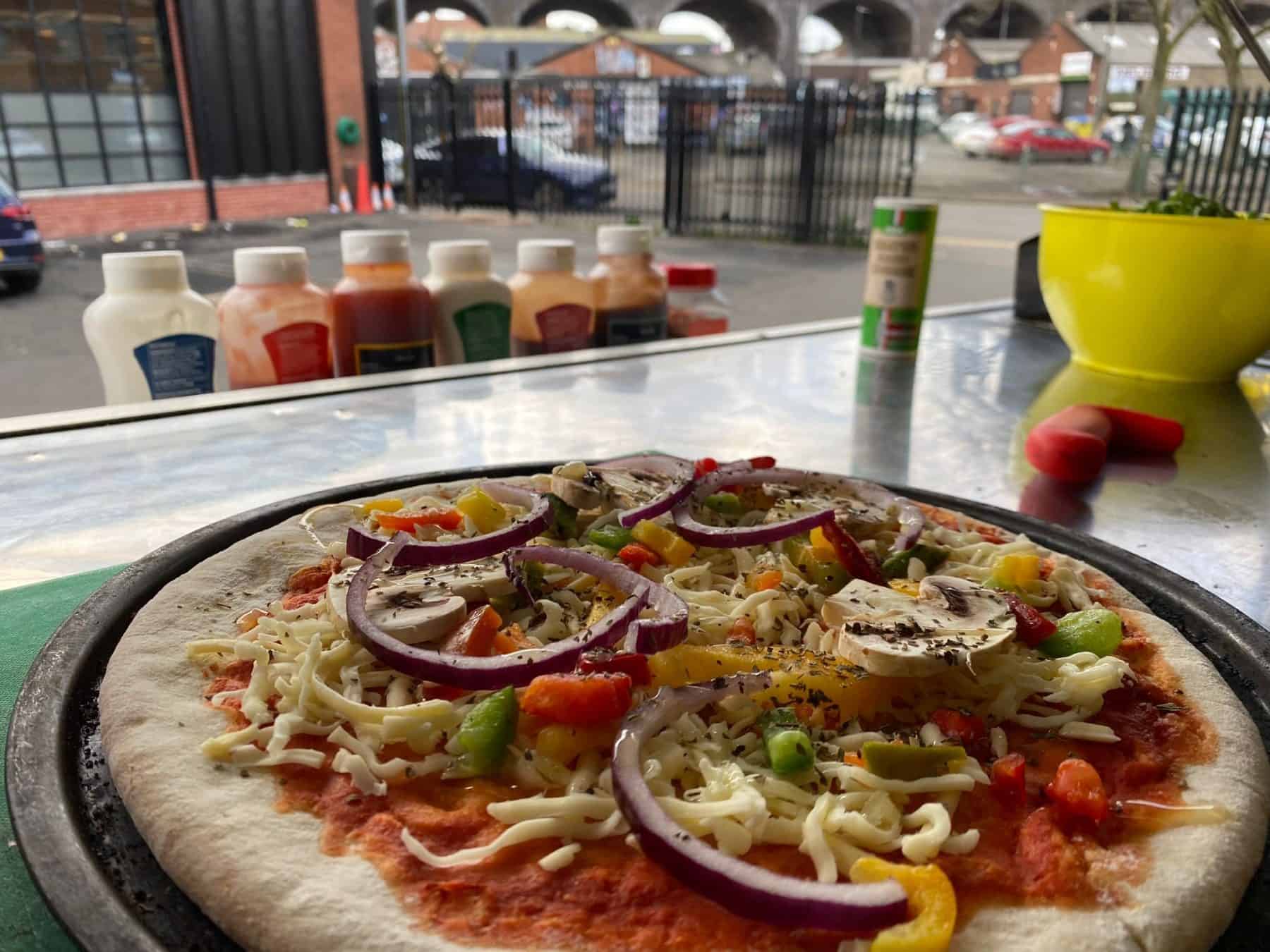 Vegan pizza with vegetables on a metal tray at KKCatering, offering fresh, delicious catering services in the UK.