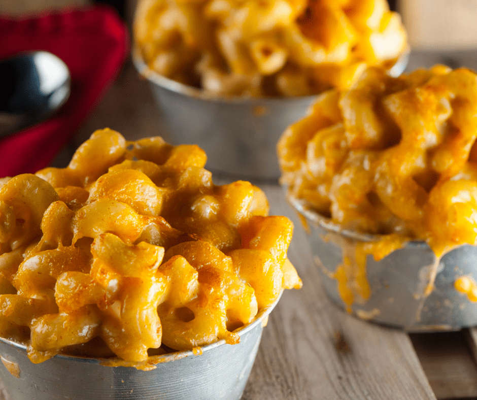 Buttered mac and cheese in metal cups, served as catering comfort food.