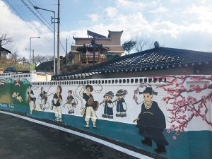 Gyo-dong in Jecheon includes a street of homes that feature murals depicting traditional Korean art and rituals. Here the wall shows the traditional celebration for a man who was approved to serve as a civil official. [LEE SUN-MIN]