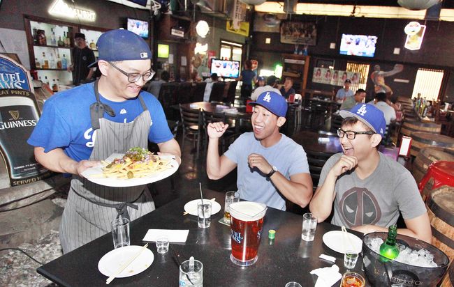 Dodger fans rooting for their team during the National League Championship Series Game 4 at Koreatown bar Mokmarjong on Wednesday. Sang Jin Kim