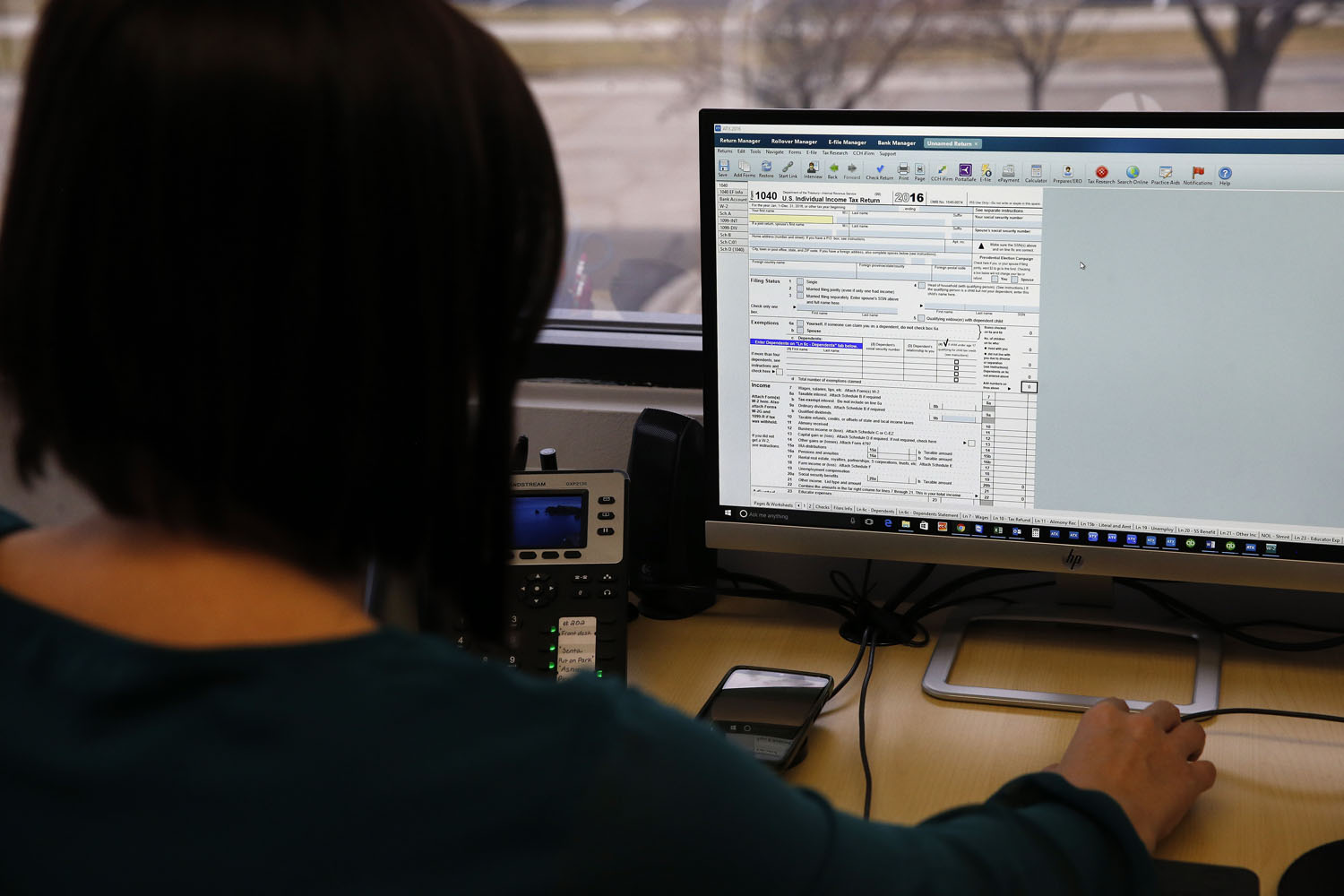 As the tax report season is underway, the interest in possible deduction is growing larger by the day. The most beneficial way to do so is by opening a retirement or health savings account. A tax expert is filling out a digital tax report.